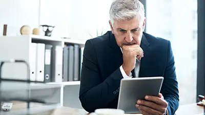 Applied Analytics: Sales Account Rounding Dashboard A focused businessman looking at a tablet in his hand